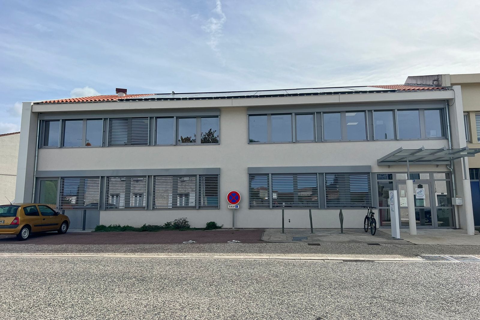 Ancien siège communautaire de Marennes-Hiers-Brouage réhabilité : bureaux isolés par l’extérieur, brise-soleil et panneaux photovoltaïques en toiture.