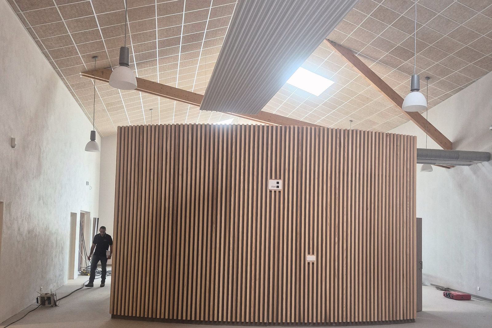 Halle du centre de formation de la CCI à Saintes : volume courbe habillé de tasseaux bois sous un plafond acoustique.