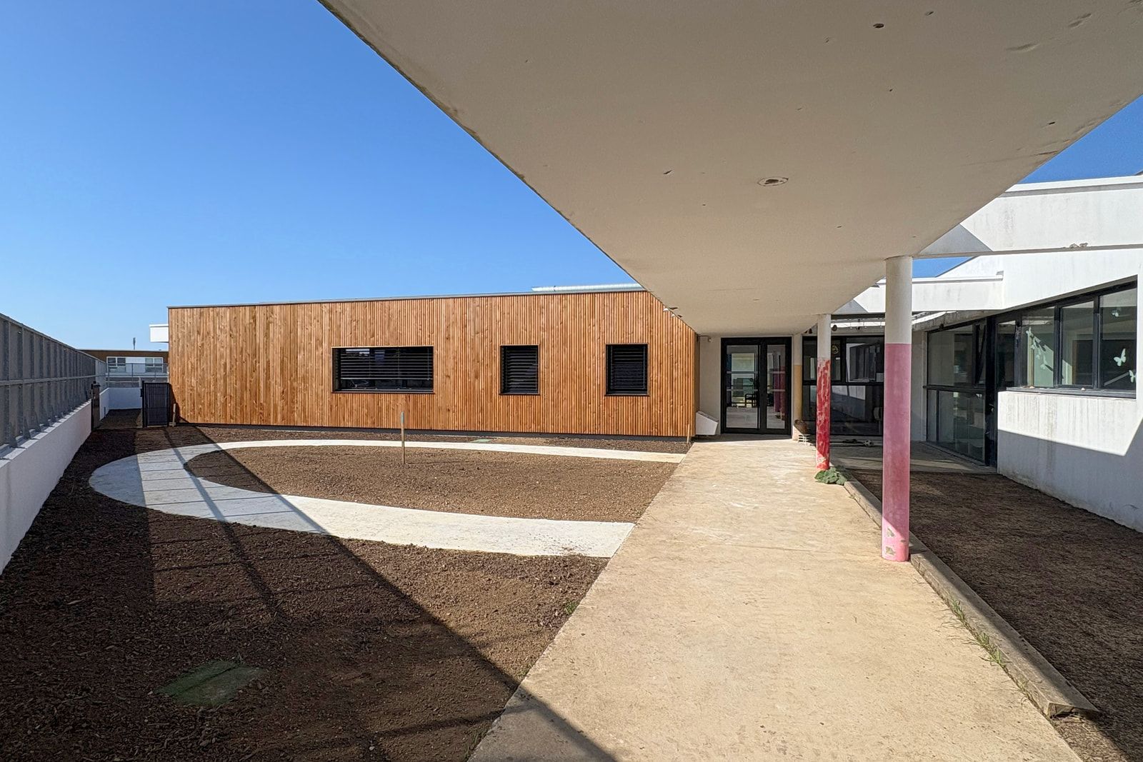 Extension en bardage bois de la crèche multi-accueil de l’Oranger à Périgny, vue depuis le préau de la cour.