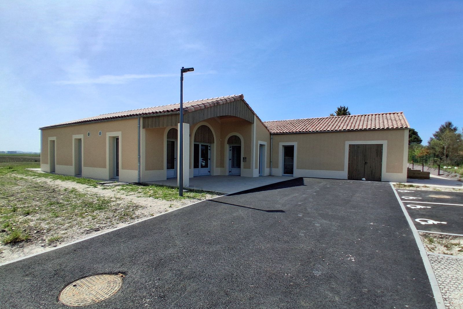 Habitat inclusif ADMR de Salignac-sur-Charente : quatorze studios de plain-pied sous tuiles, entrée sous porche à arcades.
